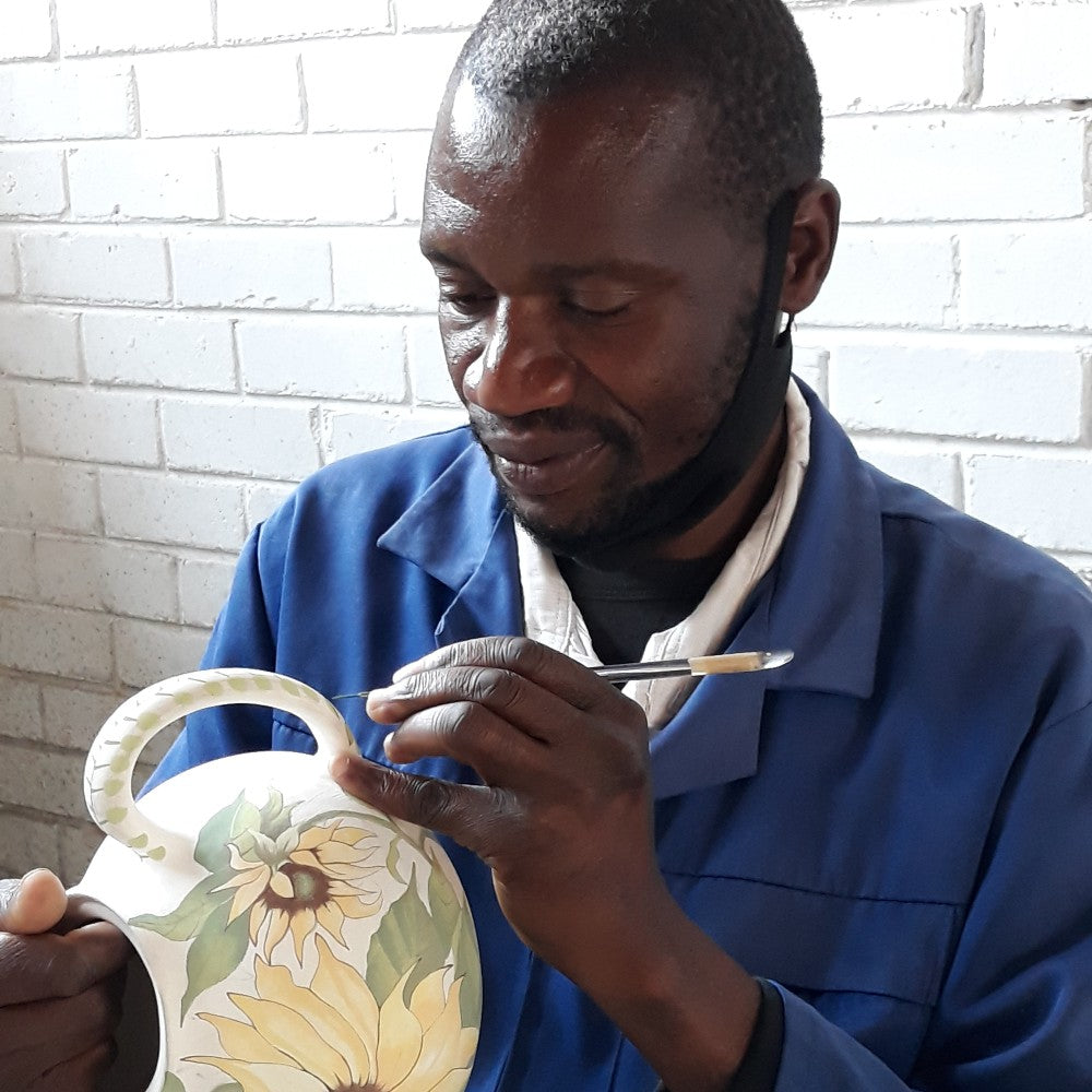 Christopher Machiri decorating a jug.