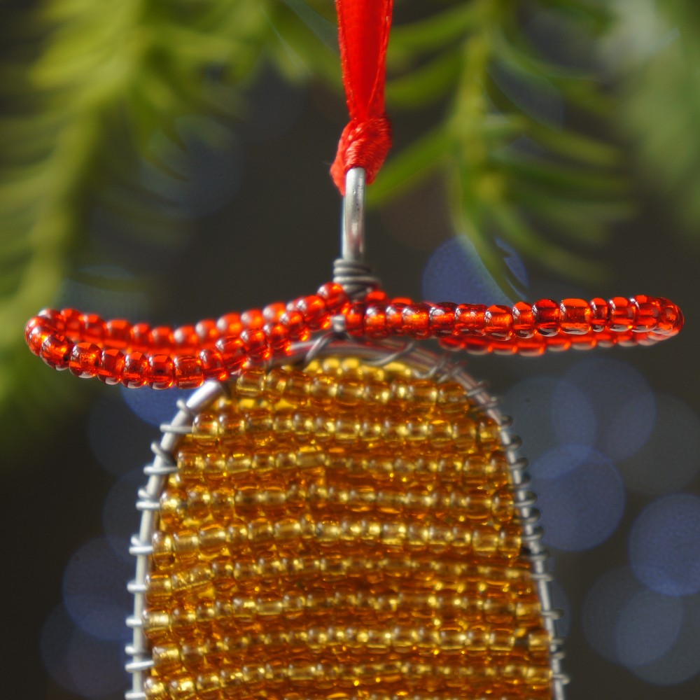 Beaded red bow atop the bell