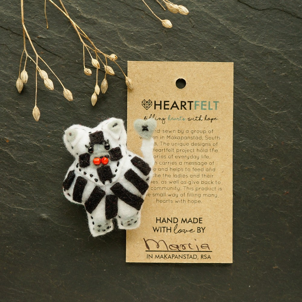 Handmade striped zebra brooch on a 'Heartfelt' card against a dark surface